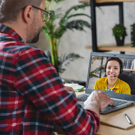 A man working with a female video interpreter on his laptop